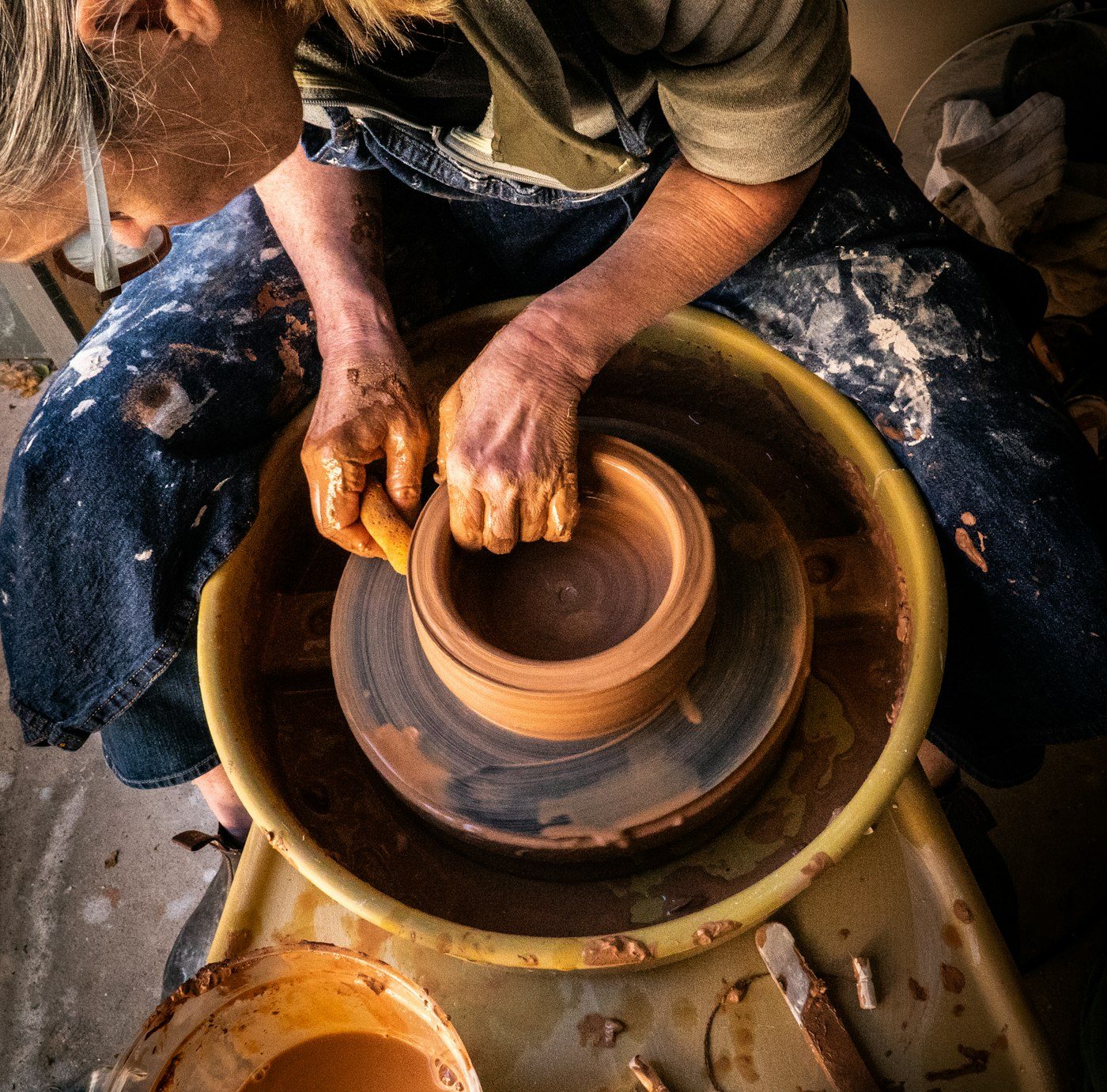 A potter shaping clay on the wheel